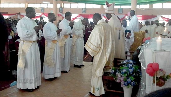 Deacons Kevin Abakisi, Robert Abotzabire, Albert Wugaa and Peter Akudugu stand before Bishop Alfred Agyenta of the Diocese of Navrongo-Bolgatanga during their ordination to the priesthood Dec. 1 in Bawku, Ghana. The four men studied at the St. Paul Seminary.