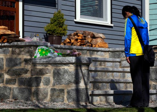 Boston Marathon runner Megan Cloke pauses after leaving flowers on the doorstep of 8-year-old Martin Richard's home in the Dorchester neighborhood of Boston April 16. The boy, a former student at Pope John Paul II Catholic Academy, was one of three peopl e killed when two bombs exploded in the crowded streets near the finish line of the marathon the previous day. More than 140 people were injured, including the boy's mother and sister who were seriously injured. CNS photo/Brian Snyder, Reuters