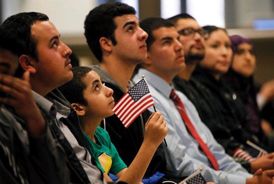 Mohamed Farag, 12, is joined by adults to watch a video after receiving proof of U.S. citizenship during a ceremony in San Francisco last Jan. 30. CNS photo / Robert Galbraith, Reuters