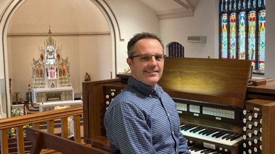 Ryan Flicek, director of music ministry and the organist at St. Nicholas in New Market, is pictured in a familiar place: the church choir loft.