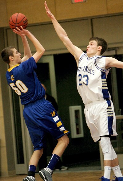 Junior guard Adam Hoffman of the Academy of Holy Angels in Richfield tries to block a shot by senior guard Bradley Carlson of Wayzata High School during the championship game of The Catholic Spirit Christmas Basketball Tournament Dec. 29 at the University of St. Thomas. Wayzata won the game, 75-70, and captured the championship for the third year in a row. This was Holy Angels' first appearance in the title game. (Dave Hrbacek / The Catholic Spirit)