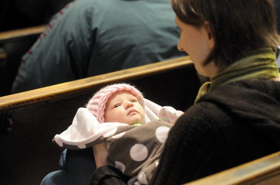 Ali Gardner, a member of the Cathedral of St. Paul, holds her 2-week-old daughter Claire during the prayer service. (Dianne Towalski/The Catholic Spirit)
