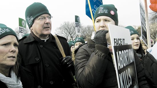 Archbishop John Nienstedt stands with Nancy Schulte Palacheck, left, and Genevieve McCarthy, then a senior at Providence Academy in Plymouth, during a rally on the National Mall in Washington, D.C. in this 2011 file photo. Archbishop Nienstedt will again join a group of students from the archdiocese participating in the rally and March for Life. Jan. 25. File photo by Maria Wiering Pedersen