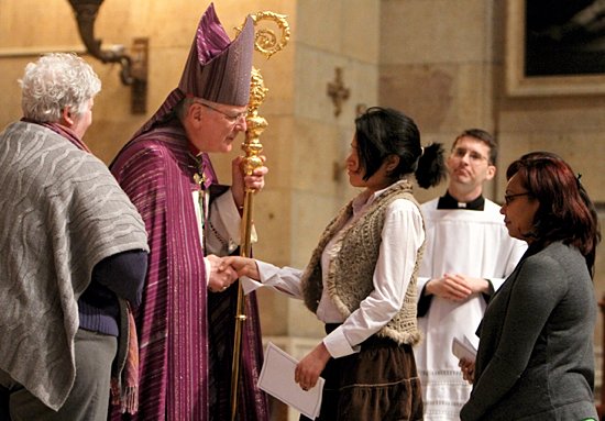 Catechumen Jacqueline Aleman, who is going through RCIA at St. Mark in St. Paul, greets Archbishop John Nienstedt during The Rite of Election and The Call to Continuing Conversion at the Cathedral of St. Paul Feb. 17. At left is Elisa Cady, RCIA director at St. Mark, and at right is Beatriz Panameno, one of Aleman’s sponsors. The rite marks the beginning of the final preparation of catechumens (those not baptized) for the sacraments of initiation, typically celebrated at the Easter Vigil. From the time of the Rite of Election until the time of their initiation, the catechumens are referred to as “members of the elect.” During the Call to Continuing Conversion, individuals who already are baptized and who are preparing for entrance into the Catholic Church are recognized. (Dave Hrbacek/The Catholic Spirit)