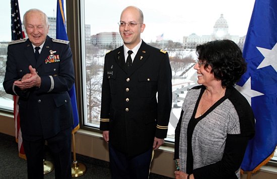 Father Michael Creagan, center, receives applause from his uncle, retired Gen. Robert Reed, left, and his mother, Judy Green, following his official commissioning Feb. 28 as a Minnesota Army National Guard Chaplain. Gen. Reed came to the Twin Cities from his home in South Carolina to conduct the swearing in. Green belongs to St. Michael in Stillwater, a parish where Father Creagan has served. He now is the pastor of St. Joseph in West St. Paul. (Dave Hrbacek / The Catholic Spirit)