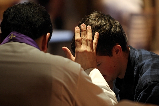 A priest hears a young man's confession in this file photo. CNS photo / Gregory A. Shemitz