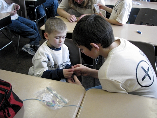 St. Croix Catholic School in Stillwater held its second annual day-long “Faith Rally” on Jan. 31. The day of faith started with an all-school Mass, followed by the demonstration of a living rosary, saint activities, service projects, and prayer. Above, Ben Corbid, a 7th-grader, works with kindergartener Chase Yocum to create a rosary bracelet during the service project portion of the day. Photo courtesy of St. Croix Catholic School