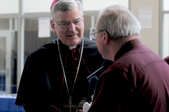 Archbishop Nienstedt talks with a participant during the breakfast break.