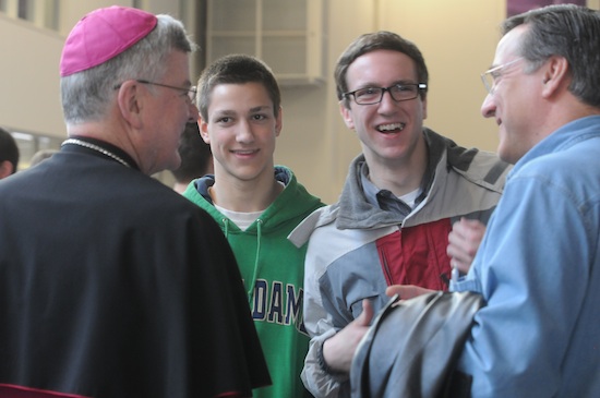 Archbishop Nienstedt visits with Karl Skogan, left, and his sons Elliott, a student at UST and Paul, 16, during the breakfast break. The Skogans are members of St. Jude of the Lake in Mahtomedi. Nearly 1700 men from around the archdiocese gathered at the University of St. Thomas March 16 for the annual Archdiocesan Men’s Conference. The event began with a Mass and included presentations from Archbishop John Nienstedt, Raymond de Sousa and Glenn Caruso, UST football coach.