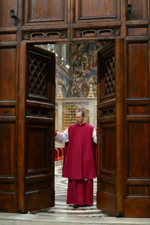 Msgr. Guido Marini, master of papal liturgical ceremonies, closes the doors to the Vatican's Sistine Chapel March 12. CNS photo/L'Osservatore Romano