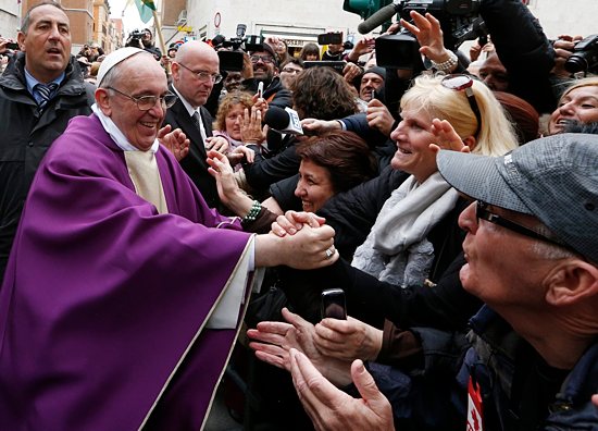 Pope Francis greets people after celebrating Mass at St. Anne Parish within the Vatican March 17. The new pope greeted every person leaving the small church and then walked over to meet people waiting around St. Anne's Gate. CNS photo / Paul Haring