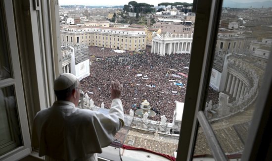 Pope Francis waves to the crowd from the window of his private apartment as he leads his first Angelus in St. Peter’s Square at the Vatican March 17. CNS photo / L'Osservatore Romano