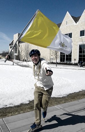 Junior seminarian Nathaniel  Binversie celebrates in the Lower Quad at the sign of white smoke, yelling to others “We have a pope!” Binversie waved the Vatican flag while roller blading through the middle of campus. Caroline Rode / TommieMedia