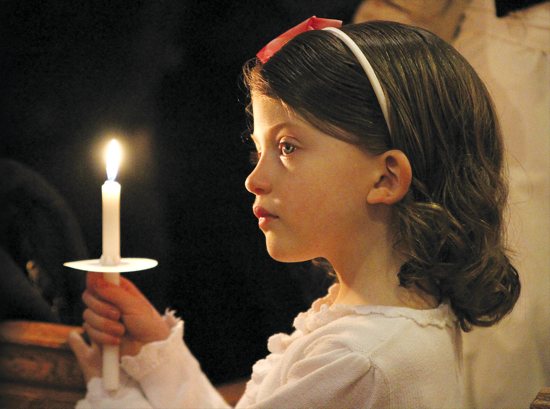 Helena Costanzo of Nativity of Our Lord in St. Paul enjoys Mass by candlelight during the Easter Vigil March 31. She was there with her siblings and parents, Dan and Christine. Turn to page 19 to learn more about the 50-day Easter season. Dave Hrbacek / The Catholic Spirit