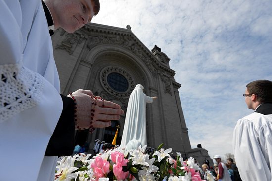 First year seminarian Matthew Goldammer holds his rosary standing by the statue of the Immaculate Heart of Mary during the procession.