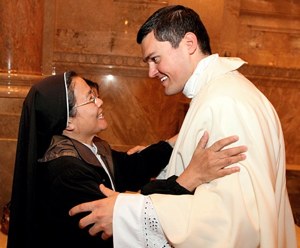Newly-ordained Father Spencer Howe greets Sister Rose Vu, a member of the Religious of the Good Shepherd, after the ordination Mass. (Dave Hrbacek / The Catholic Spirit)