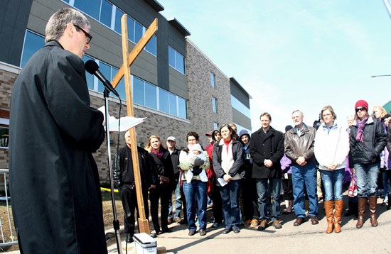Father Michael Becker, left, rector of St. John Vianney College Seminary in St. Paul, leads prayer during the annual Good Friday prayer service for life in front of Planned Parenthood in St. Paul. Hundreds of people throughout the day came to pray and march in front of the abortion facility. Archbishop John Nienstedt came in the morning to lead and join others in prayer. (Dave Hrbacek/The Catholic Spirit)