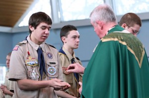 Life Scout Daniel Pelis receives Communion from Msgr. Robert Thelen during a Feb. Mass at Holy Cross Church in Nesconset, N.Y., to marking Scout Sunday. This year Scout Sunday coincided with the 105th anniversary of the founding of the Boy Scouts of America. (CNS photo/Gregory A. Shemitz)