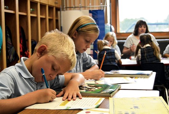 Joe Macke and Addison Hynes are hard at work in teacher Jennifer Bolduc’s first and second grade class at Mary, Queen of Peace School in Rogers.