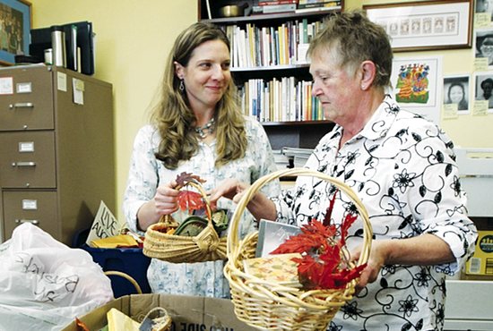 Andrea Pearson Tande, left, and St. Joseph Sister Suzanne Herder sort baskets for the silent auction of the annual St. Joseph Worker Program fundraiser, a Taste of Thanksgiving, which takes place Nov. 6 at Cretin-Derham Hall High School in St. Paul. Pearson Tande, who belongs to St. Cecilia in St. Paul, is the program coordinator and is nearing the completion of her two-year process to become a lay consociate with the Sisters of St. Joseph of Carondelet. Dave Hrbacek/The Catholic Spirit