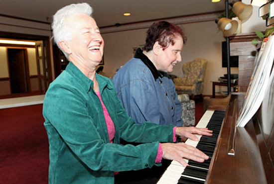 Living Word Sister Mary Nicholas Eiden, left, plays piano and sings with Martha Lambert, a resident of Castle Ridge in Eden Prairie, a care center of Presbyterian Homes and Services. Dave Hrbacek/The Catholic Spirit