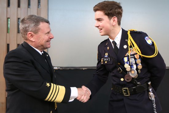 Admiral Bill Gortney talks with St. Thomas Academy senior Brendan Quinlan following his presentation on leadership at the school Jan. 14. Quinlan presented him with two gifts at the end, including a pair of heavy mittens. Dave Hrbacek/The Catholic Spirit 