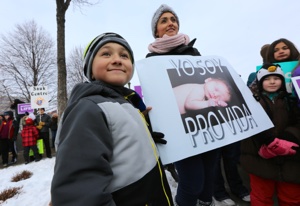 Teresa Patiño, center, of Risen Savior in Burnsville, holds a sign in Spanish that translates, "I am pro-life." At left is her son, Alek Gabriel, 8. "He is a survivor," Patiño said, indicating that she considered abortion when she was pregnant with him in 2007. "I cancelled my abortion appointment. He's gift. . . . I got the wrong [phone] number and it ended up being a pro-life center instead of an abortion clinic." Dave Hrbacek/The Catholic Spirit