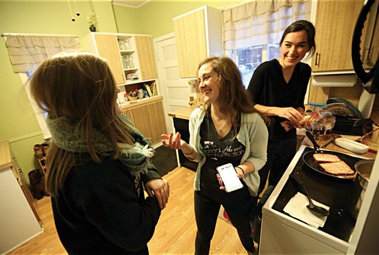 From left, Kaly Kohns, Lauren DeZelar and Jackie Meyer laugh as they prepare dinner in the kitchen of an SPO women’s household near the University of Minnesota. DeZelar and Meyer live in the house, while Kohns is a frequent guest. Dave Hrbacek/The Catholic Spirit