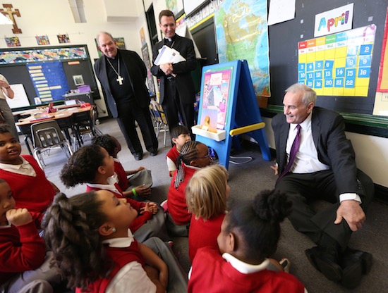Gov. Mark Dayton talks with first-graders at Ascension School in north Minneapolis during a visit April 22. In the background observing the conversation are Archbishop Bernard Hebda, left, and Bishop Andrew Cozzens, who extended the invitation to Gov. Dayton to visit the school. Dave Hrbacek/The Catholic Spirit