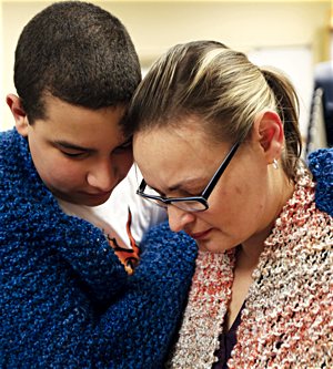 Veronica Rosa and her 12-year-old son, parishioners of St. John the Baptist in Savage, share a moment after receiving prayer shawls during a session of PALS March 3. 