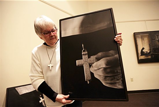 Sister Suzanne Homeyer, a Visitation Sister of Minneapolis, holds artwork depicting a Visitation nun in Annecy, France, her order’s birthplace. All Visitation sisters wear the same silver cross. Sister Suzanne said community members exchange crosses each New Year’s Day in the spirit of founder St. Francis de Sales, who didn’t want the sisters to “get attached to things.” Photo by Dave Hrbacek/The Catholic Spirit