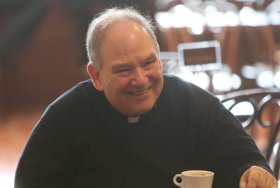 Archbishop Bernard Hebda celebrates his appointment to the Archdiocese of St. Paul and Minneapolis March 24 with archdiocesan priests and staff over coffee and biscotti at Cossetta’s Pasticceria in St. Paul. Dave Hrbacek/The Catholic Spirit