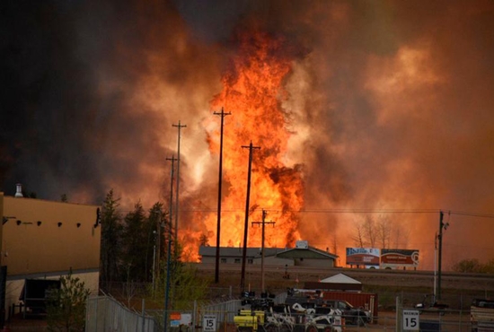 Flames from a wildfire rise in an industrial area of Fort McMurray, Alberta, May 4. The entire city has been evacuated because of the wildfire. CNS photo/courtesy CBC News via Reuters