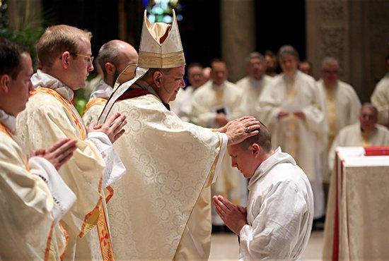 Archbishop Bernard Hebda lays hands on Bryce Evans to ordain him a transitional deacon May 14 at the Basilica of St. Mary in Minneapolis. Also ordained transitional deacons were  Paul Baker, Nicholas Froehle, Matthew Quail, Timothy Sandquist, Matthew Shireman, Brandon Theisen, Chad VanHoose and Benjamin Wittnebel. Dave Hrbacek/ The Catholic Spirit