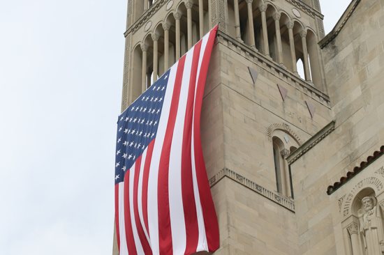 A large American flag is seen hanging from the bell tower of the Basilica of the National Shrine of the Immaculate Conception in Washington July 4, 2015. The U.S. bishops' fifth annual Fortnight for Freedom opens June 21. CNS/Bob Roller