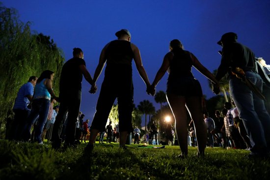 People hold hands in a circle during a June 12 vigil in an Orlando, Fla., park following a mass shooting at the Pulse gay nightclub in that city earlier that morning. CNS/Carlo Allegri, Reuters