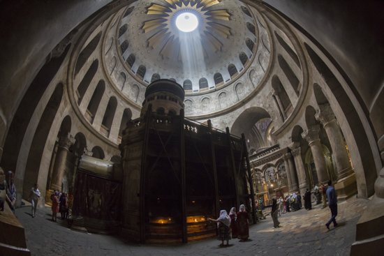 Tourists and Christian pilgrims visit the tomb where it is believed Christ was buried inside the Church of the Holy Sepulcher in Jerusalem April 17. For the first time in 200 years, experts have begun a restoration of the Edicule of the Tomb. CNS/Jim Hollander, EPA