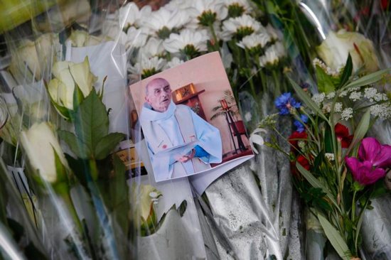 A photo of slain Father Jacques Hamel is seen among flowers at a makeshift memorial in Saint-Etienne-du-Rouvray, near Rouen, France, July 27. CNS photo/Ian Langsdon, EPA