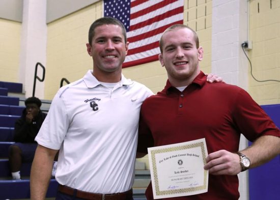 Olympic wrestler Kyle Snyder holds his honorary diploma from Our Lady of Good Counsel High School in Olney, Md., Sept. 23, 2015. Standing next to him is his former coach Skylar Saar. CNS photo/courtesy Our Lady of Good Counsel High School