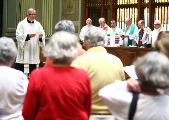 Father G. Dennis Gill, rector of the Cathedral Basilica of SS. Peter and Paul in Philadelphia, prays July 25 with clergy from Christian and Jewish congregations in the Philadelphia area at an interfaith service hosted at the cathedral. CNS photo/Sarah Webb, Archdiocese of Philadelphia