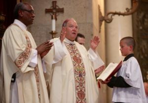 Archbishop Bernard Hebda, center, reads a prayer during Mass for the Preservation of Peace and Justice at the Cathedral of St. Paul July 8. At left is Deacon Phillip Stewart. Concelebrating were Father John Ubel, rector of the Cathedral, Msgr. Aloysius Callaghan, rector of the St. Paul Seminary, and Father Michael Creagan, pastor of St. Joseph in West St. Paul. Dave Hrbacek/The Catholic Spirit