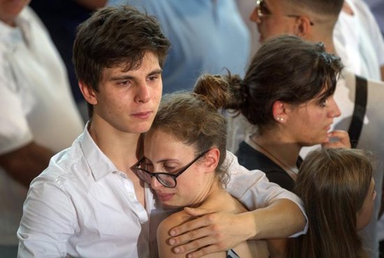 A man comforts a woman after an Aug. 27 mass funeral for earthquake victims inside a gym in Ascoli Piceno, Italy. Pope Francis said he would visit survivors of the Aug. 24 quake "as soon as possible." The 6.2 earthquake left hundreds dead and thousands homeless. CNS photo/Adamo Di Loreto, Reuters