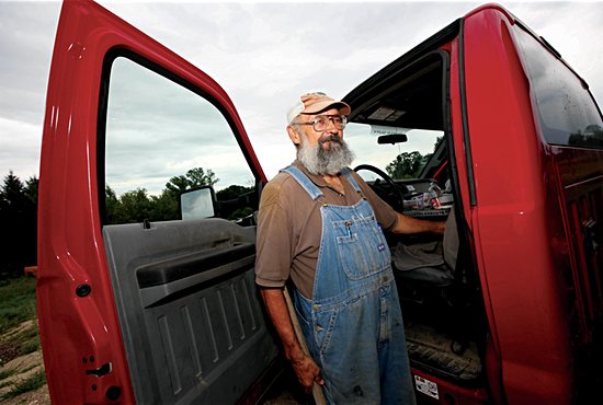 Deacon Kittok stands outside of his Ford F-450 pickup truck as he unloads dirt excavated from a nearby cemetery. Dave Hrbacek/The Catholic Spirit