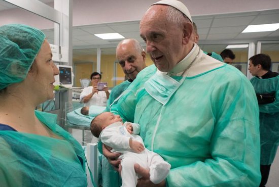 Pope Francis holds a baby as he visits the neonatal unit at San Giovanni Hospital in Rome Sept. 16. The visit was part of the pope's series of Friday works of mercy during the Holy Year. CNS photo/L'Osservatore Romano, handout