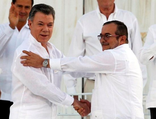 Colombian President Juan Manuel Santos and Marxist rebel leader Rodrigo Londono Echeverri of FARC, the Revolutionary Armed Forces of Colombia, shake hands Sept. 26 in Bogota after signing an agreement to end Latin America's last armed conflict. Santos has been awarded the 2016 Nobel Peace Prize. CNS photo/John Vizcaino, Reuters