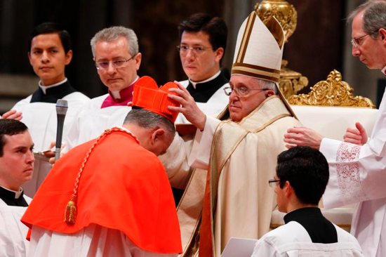 Pope Francis places a red biretta on new Cardinal John Dew of Wellington, New Zealand, during the 2015 consistory in St. Peter's Basilica at the Vatican. CNS photo/Paul Haring