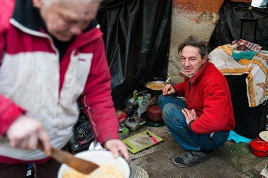 A homeless couple cooks a meal outside their makeshift shelter in late January in Budapest, Hungary. Europe's top Catholic charitable agency has published a "road map for social justice and equality," urging all church members to defend the poor and marginalized. CNS photo/Attlia Balazs, EPA