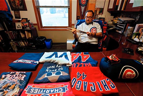 Father John W. Clemens, pastor of Our Lady of Hope Church in Rosemont, Ill., poses for a photo Oct. 27 near his jersey signed by Chicago Cubs legend Ernie Banks. Karen Callaway/Catholic New World