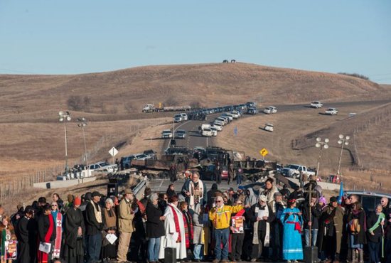 Clergy of many faiths from across the United States participate in a prayer circle Nov. 3 in front of a bridge in Standing Rock, N.D., where demonstrators confront police during a protest of the Dakota Access pipeline. Demonstrations against the pipeline are taking place on the Standing Rock Indian Reservation near Cannonball, N.D. CNS photo/Stephanie Keith, Reuters