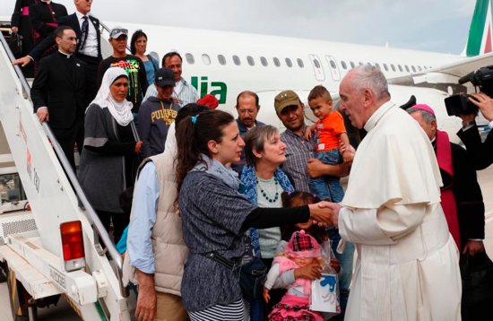 Pope Francis greets Syrian refugees he brought to Rome from the Greek island of Lesbos, at Ciampino airport in Rome April 16, 2016. The pope concluded his one-day visit to Greece by bringing 12 Syrian refugees to Italy aboard his flight. CNS photo/Paul Haring